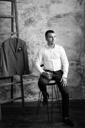 portrait of a young groom in a white shirt in a bright studioの写真素材