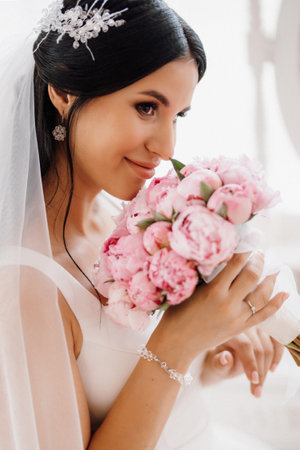 brunette bride in a tight wedding dress in a bright studio