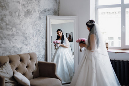 brunette bride in a tight wedding dress in a bright studioの写真素材