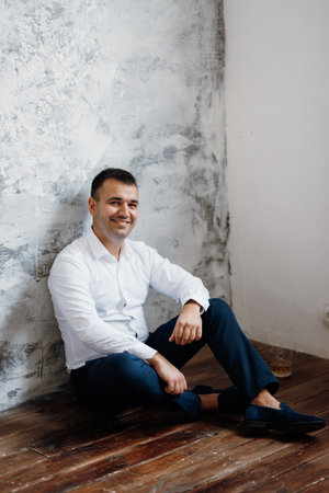 portrait of a young groom in a blue jacket and white shirt in a bright studioの写真素材