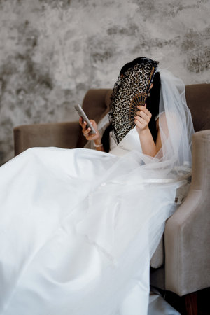 brunette bride in a tight wedding dress in a bright studioの写真素材