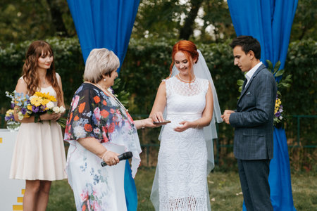 wedding ceremony of a young couple in love on a green meadow in the forestの写真素材