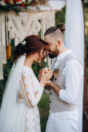 wedding ceremony of a young couple in love on a green meadow in the forestの写真素材
