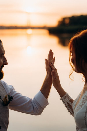 bride girl and groom near the river at sunset lightの写真素材