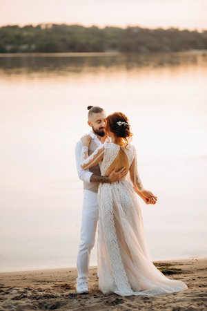 bride girl and groom near the river at sunset lightの写真素材