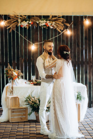the first wedding dance of the bride and groom inside the restaurant hall in sunset lightの写真素材