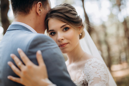 portrait of an elegant groom in a blue suit in a deciduous forest with a bouquetの写真素材