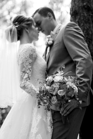 portrait of an elegant groom in a blue suit in a deciduous forestの写真素材
