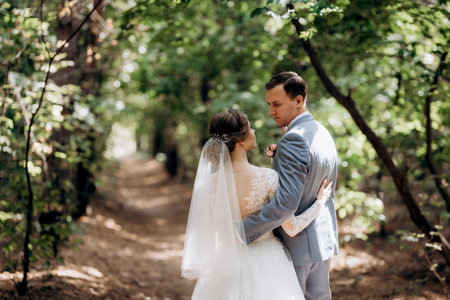 portrait of an elegant groom in a blue suit in a deciduous forestの写真素材