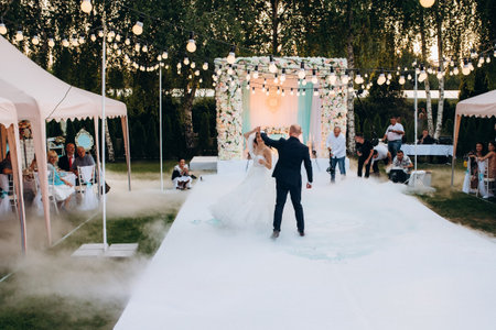 The first dance of the bride and groom in an open-air restaurant with heavy white smokeの写真素材