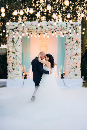 The first dance of the bride and groom in an open-air restaurant with heavy white smokeの写真素材