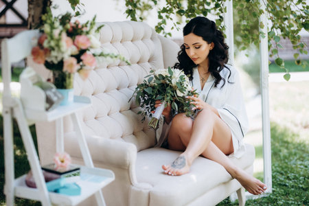 black-haired bride prepares for her wedding in a boudoir in the gardenの写真素材