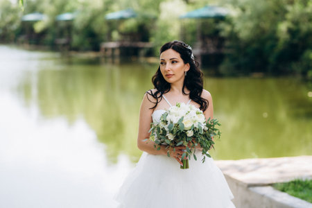 bride against the background of a yellow sunset near the riverの写真素材