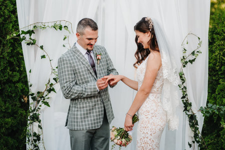 wedding ceremony of the marriage of a guy and a girl against the backdrop of an arch on a forest path