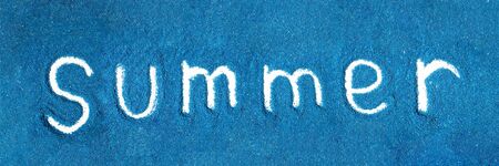 Text summer on blue small stones. Finger writingの写真素材