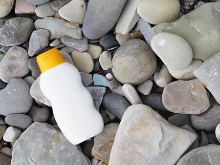 bottle of sunscreen on rocks close-up. sun protectionの写真素材