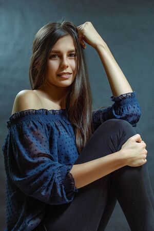 Portrait of a mulatto woman, a young brunette with long hair in a blue blouseの写真素材