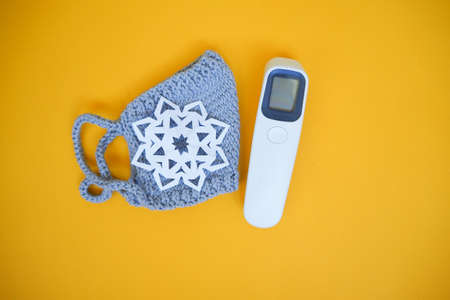 gray knitted face mask laser thermometer snowflakes Christmas medicine