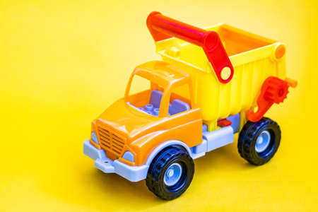 Toy truck on a yellow background with apples. Cargo transportation of fruit.の写真素材
