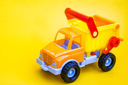 Toy truck on a yellow background with apples. Cargo transportation of fruit.の写真素材