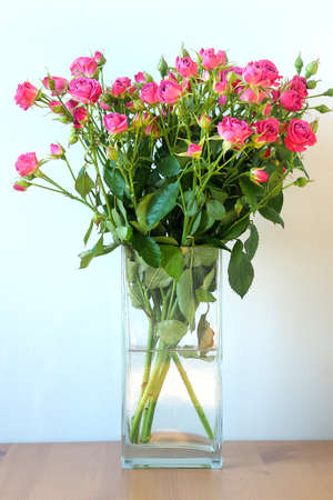 Spring blue background with a bouquet of pink roses in a vase. Postcard for Mothers Day, Womens Day, St. Valentine, March 8の写真素材