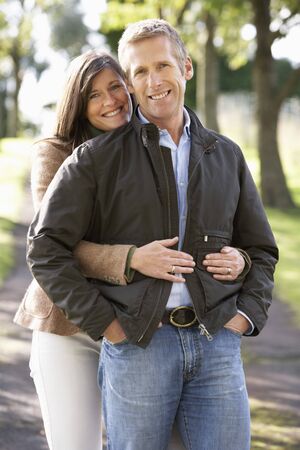 Portrait Of Romantic Couple Enjoying Outdoor Walk Through Autumn Parkの写真素材