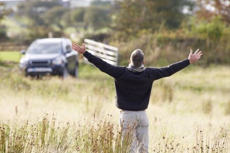 Man Enjoying Freedom Outdoors in Autumn Landscapeの写真素材