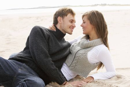 Young Romantic Couple Relaxing On Beach Togetherの写真素材