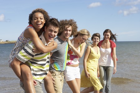 Group Of Young Friends Walking Along Summer Shorelineの写真素材