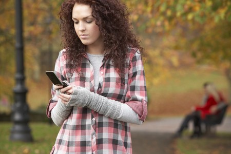 Frustrated Teenage Girl Making Mobile Phone Call In Autumn Landscapeの写真素材
