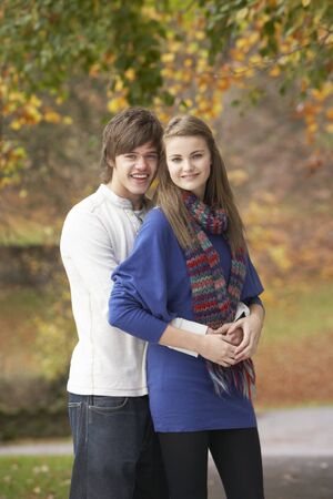 Romantic Teenage Couple In Autumn Parkの写真素材