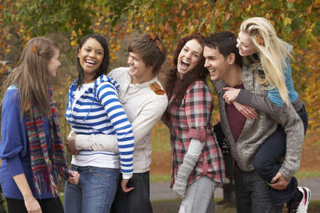 Group Of Six Teenage Friends Having Fun In Autumn Parkの写真素材