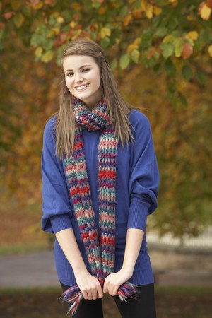 Smiling Teenage Girl Standing In Autumn Parkの写真素材