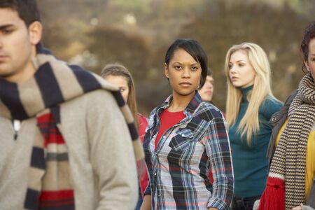 Teenage Girl Surrounded By Friends In Outdoor Autumn Landscapeの写真素材