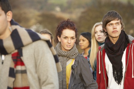 Teenage Girl Surrounded By Friends In Outdoor Autumn Landscapeの写真素材