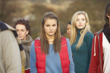 Teenage Girl Surrounded By Friends In Outdoor Autumn Landscapeの写真素材