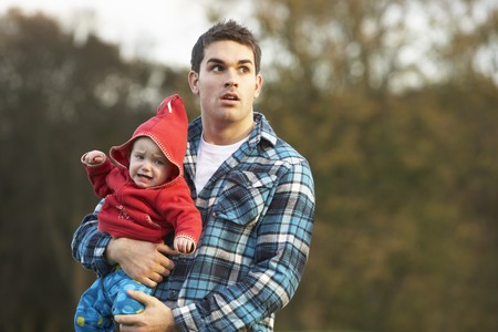 Shocked Teenage Boy Holding Babyの写真素材