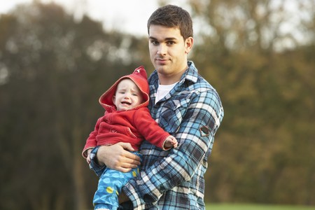 Shocked Teenage Boy Holding Babyの写真素材