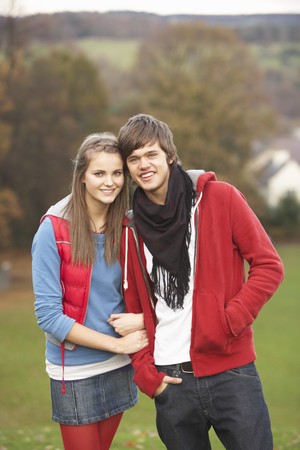 Romantic Teenage Couple Walking Through Autumn Landscapeの写真素材