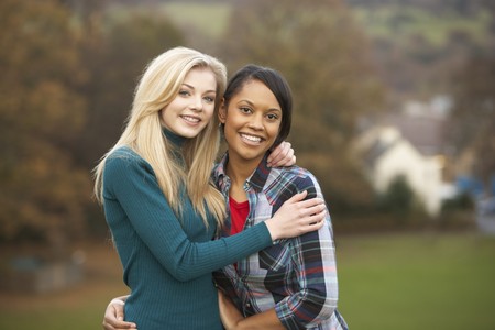 Two Female Teenage Friends On Walk In Autumn Landscapeの写真素材
