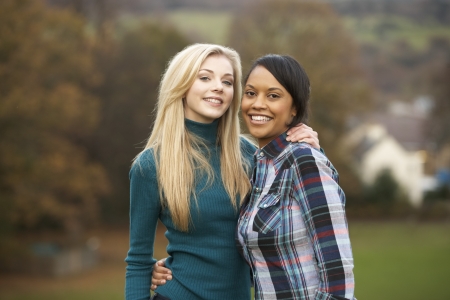 Two Female Teenage Friends On Walk In Autumn Landscapeの写真素材