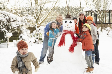 Family Building Snowman In Gardenの写真素材