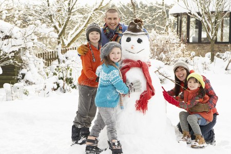 Family Building Snowman In Gardenの写真素材