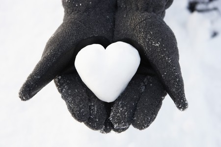 Close Up Of Hands Holding Heart Made Out Of Snowの写真素材