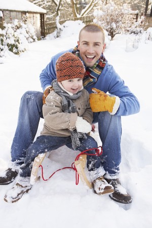Father And Son Sitting On Sledgeの写真素材