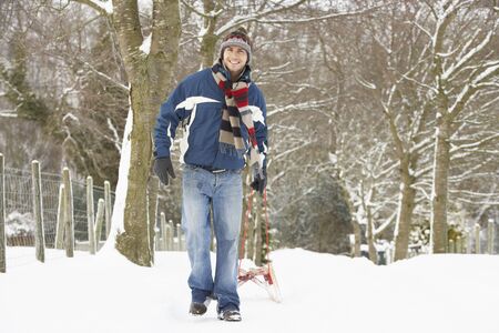 Man Pulling Sledge Through Winter Landscapeの写真素材