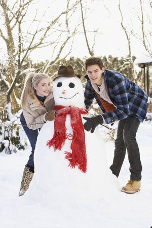 Teenage Couple Building Snowmanの写真素材