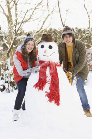 Teenage Couple Building Snowmanの写真素材