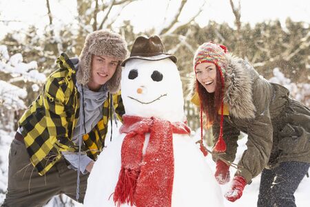 Teenage Couple Building Snowmanの写真素材