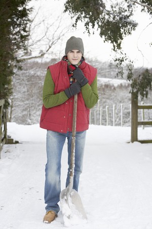 Young Man Clearing Snow From Driveの写真素材